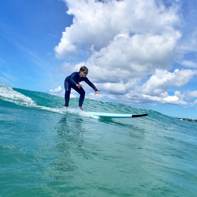 Surfer on a wave in turquoise water